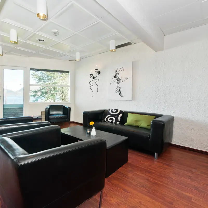 Lobbyområdet med sorte sittemøbler og grønne detaljer hos Thon Hotel Sandnes