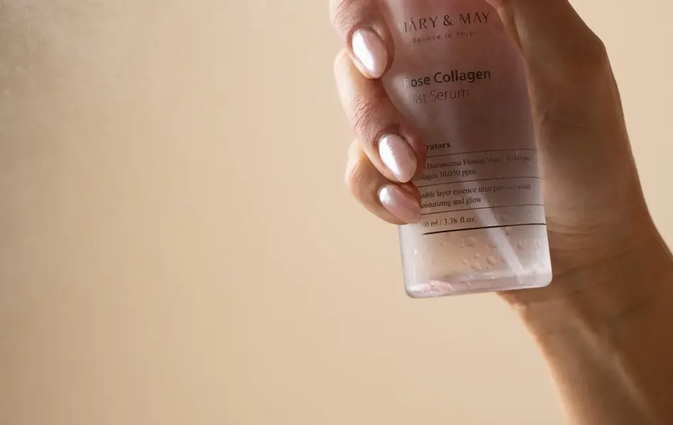 Hånd som holder en flaske med ansiktsmist og sprayer en dusj