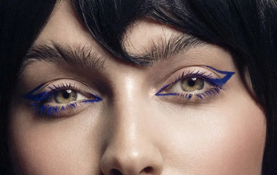 Nærbilde. Kvinne med lilla eyeliner ser mot kamera. Foto til artikkel om perfekte sminketrender til nyttårsaften.
