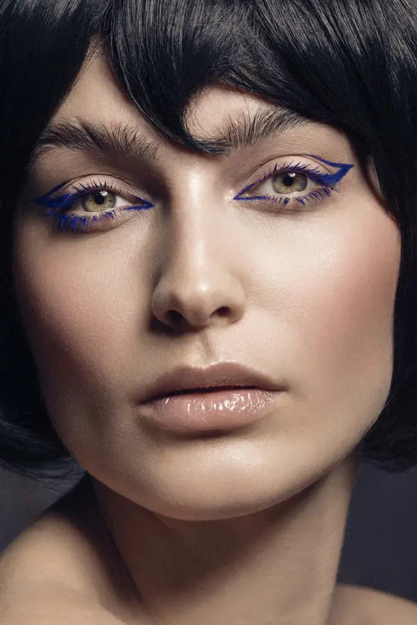 Nærbilde. Kvinne med lilla eyeliner ser mot kamera. Foto til artikkel om perfekte sminketrender til nyttårsaften.