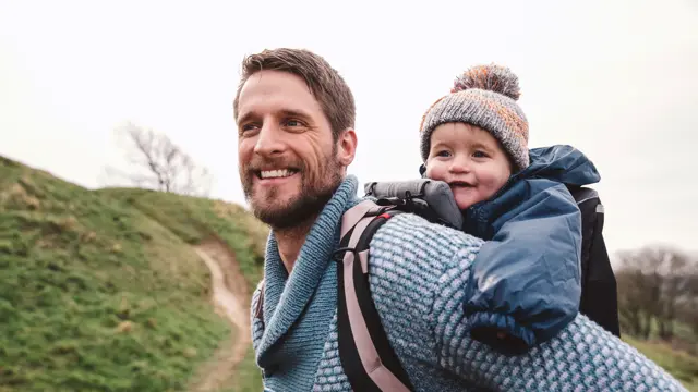 far som er ute på tur med barn i bæresele
