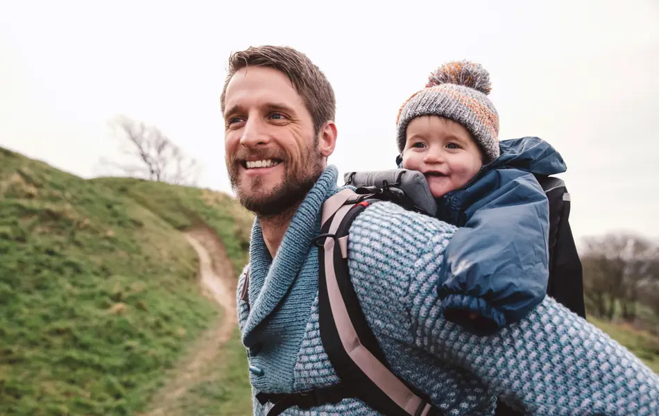 far som er ute på tur med barn i bæresele