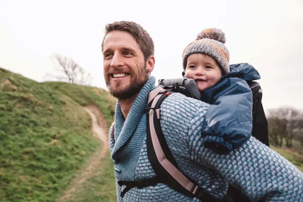 far som er ute på tur med barn i bæresele