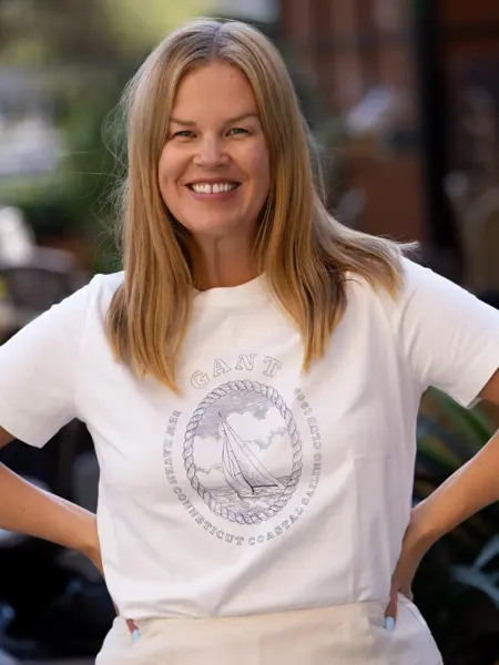 Dame med hvit Gant t-skjorte og beige skjørt