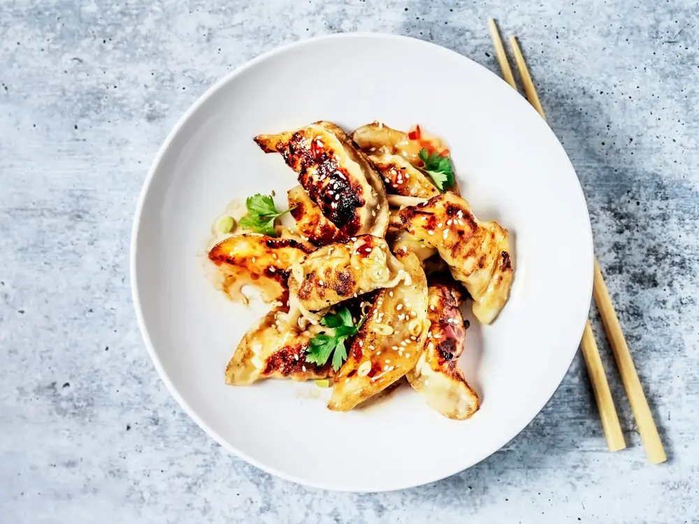 Dumplings på en tallerken og spisepinner ved siden av