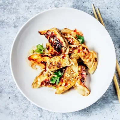 Dumplings på en tallerken og spisepinner ved siden av