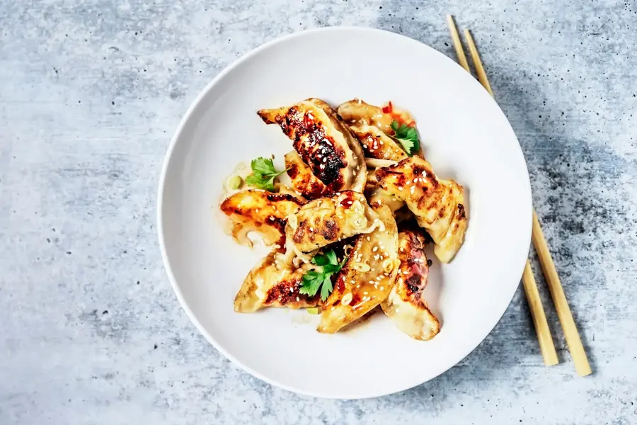 Dumplings på en tallerken og spisepinner ved siden av