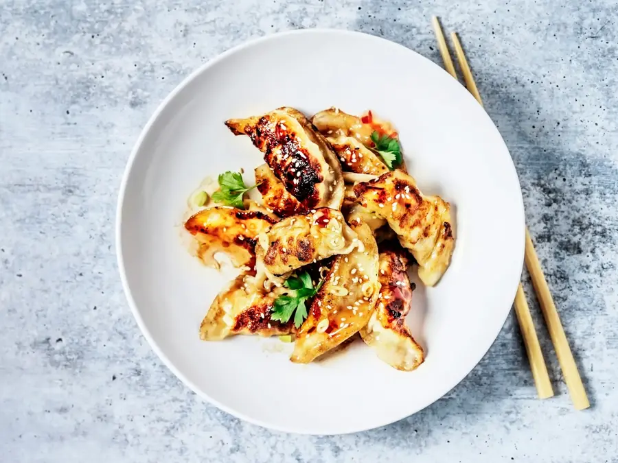 Dumplings på en tallerken og spisepinner ved siden av