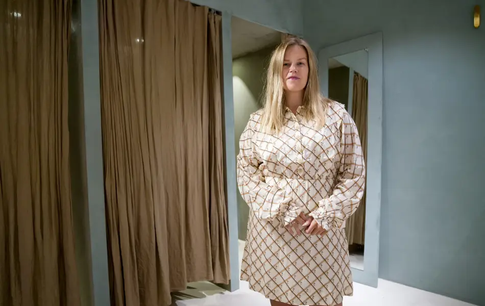 Jente med blondt hår, har på seg en mønstrete kjole 