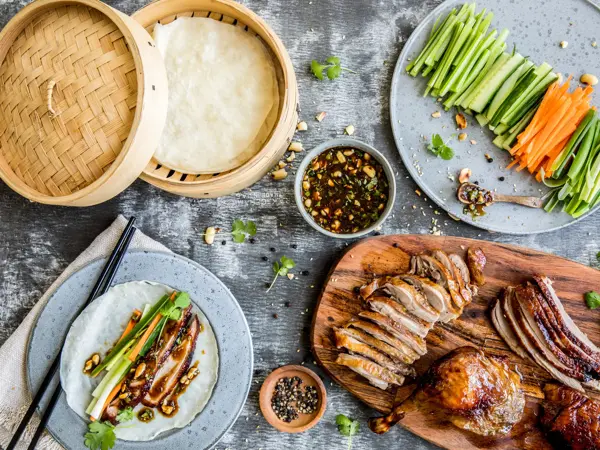 Bord sett ovenfra fylt med crispy duck og tilbehør