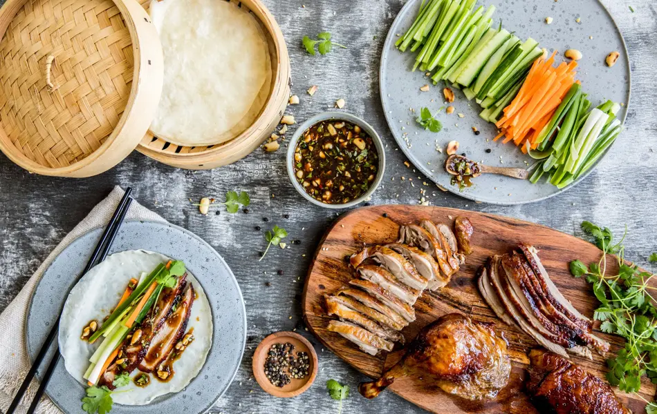 Bord sett ovenfra fylt med crispy duck og tilbehør