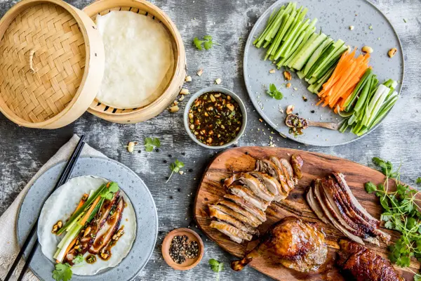 Bord sett ovenfra fylt med crispy duck og tilbehør