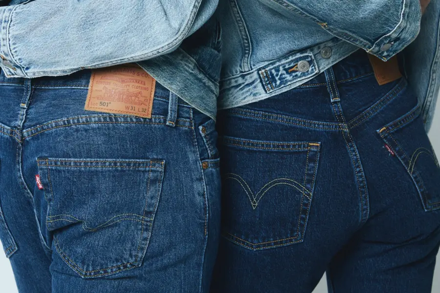 Nærbilde av bakdelen til to mennesker, hvor begge har på mørke jeans og holder rundt livet til hverandre