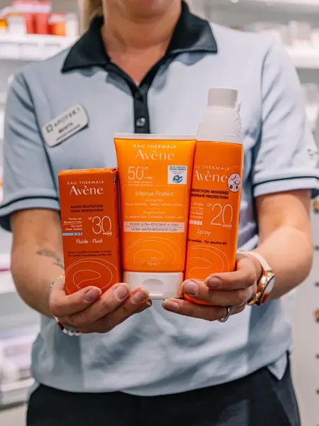 Dame som holder frem solkrem