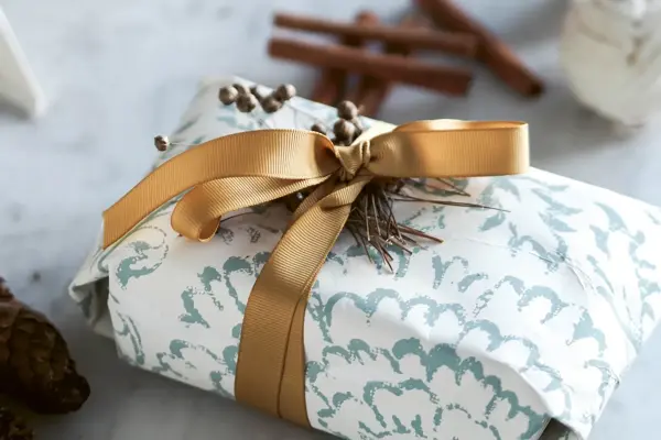 julegave som er fint dekorert med gull gavebånd
