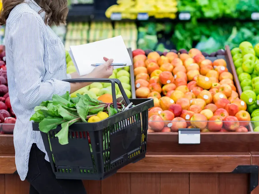 Svart handlekurv med varer i matbutikk