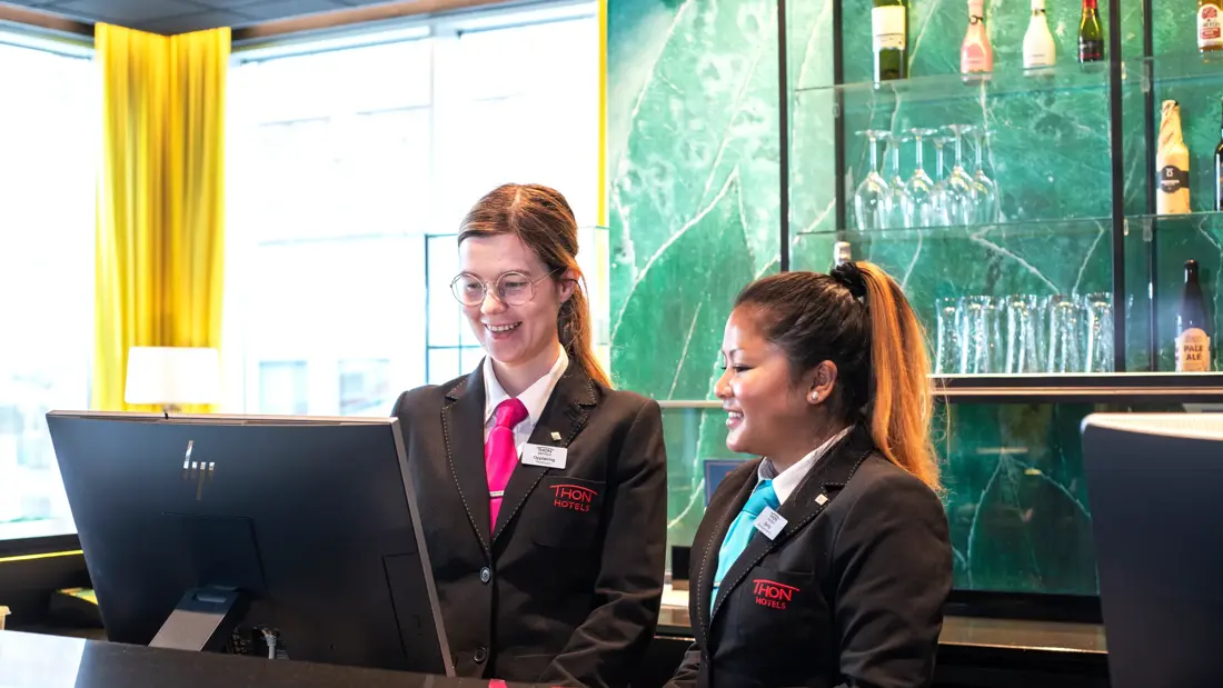 Resepsjon, to ansatte i uniform