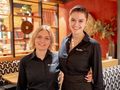 To som holder rundt hverandre og smiler til kamera