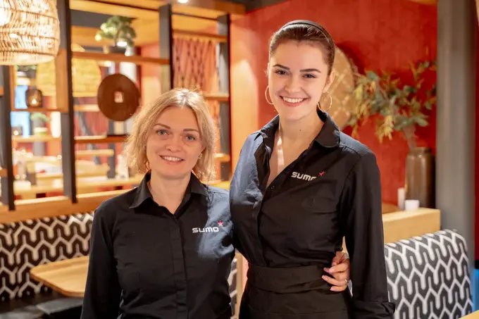 To som holder rundt hverandre og smiler til kamera