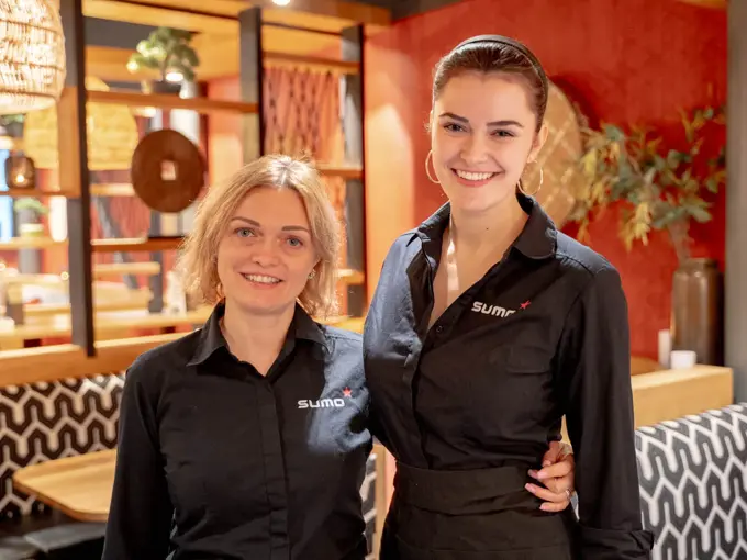 To som holder rundt hverandre og smiler til kamera