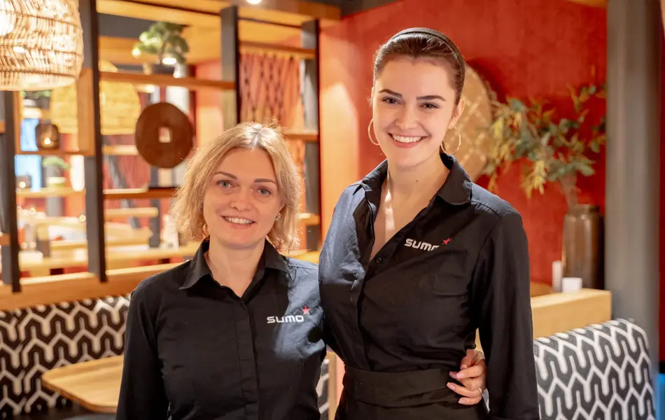 To som holder rundt hverandre og smiler til kamera