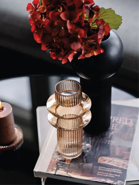 Lysbeholder og en vase med rød blomster