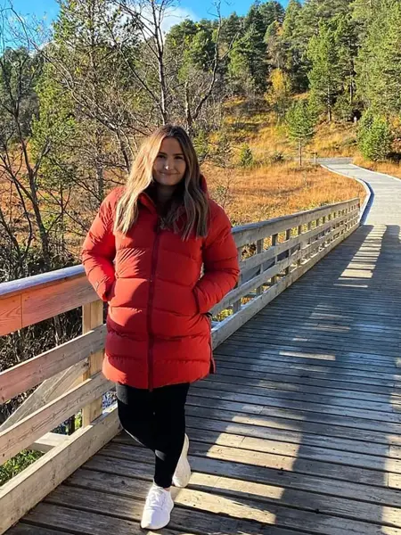 ung kvinne ute i frisk luft med rød vinterjakke