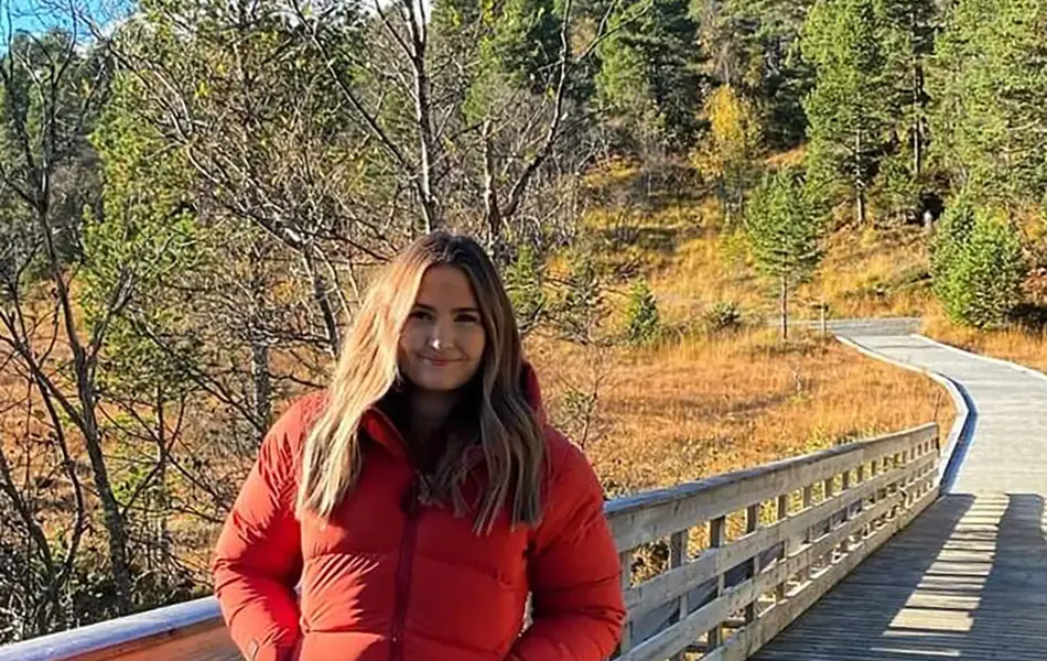 ung kvinne ute i frisk luft med rød vinterjakke