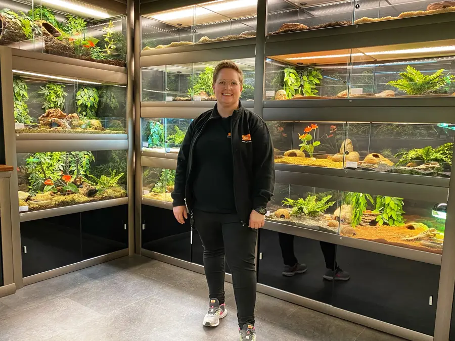 Dame står foran bur som inneholder reptiler