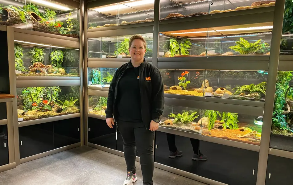 Dame står foran bur som inneholder reptiler