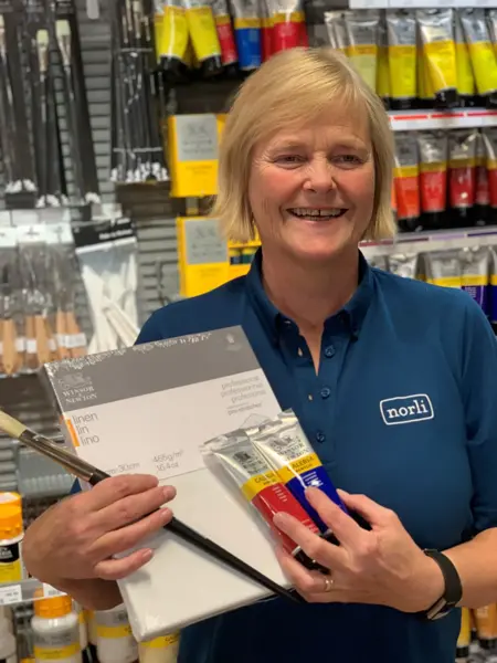 ansatt hos norli viser frem produkter