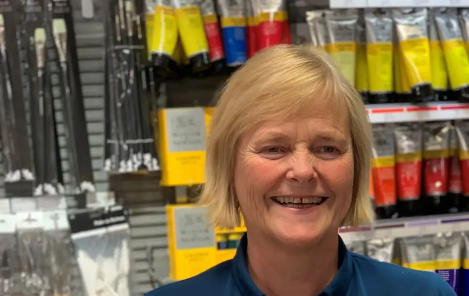 ansatt hos norli viser frem produkter