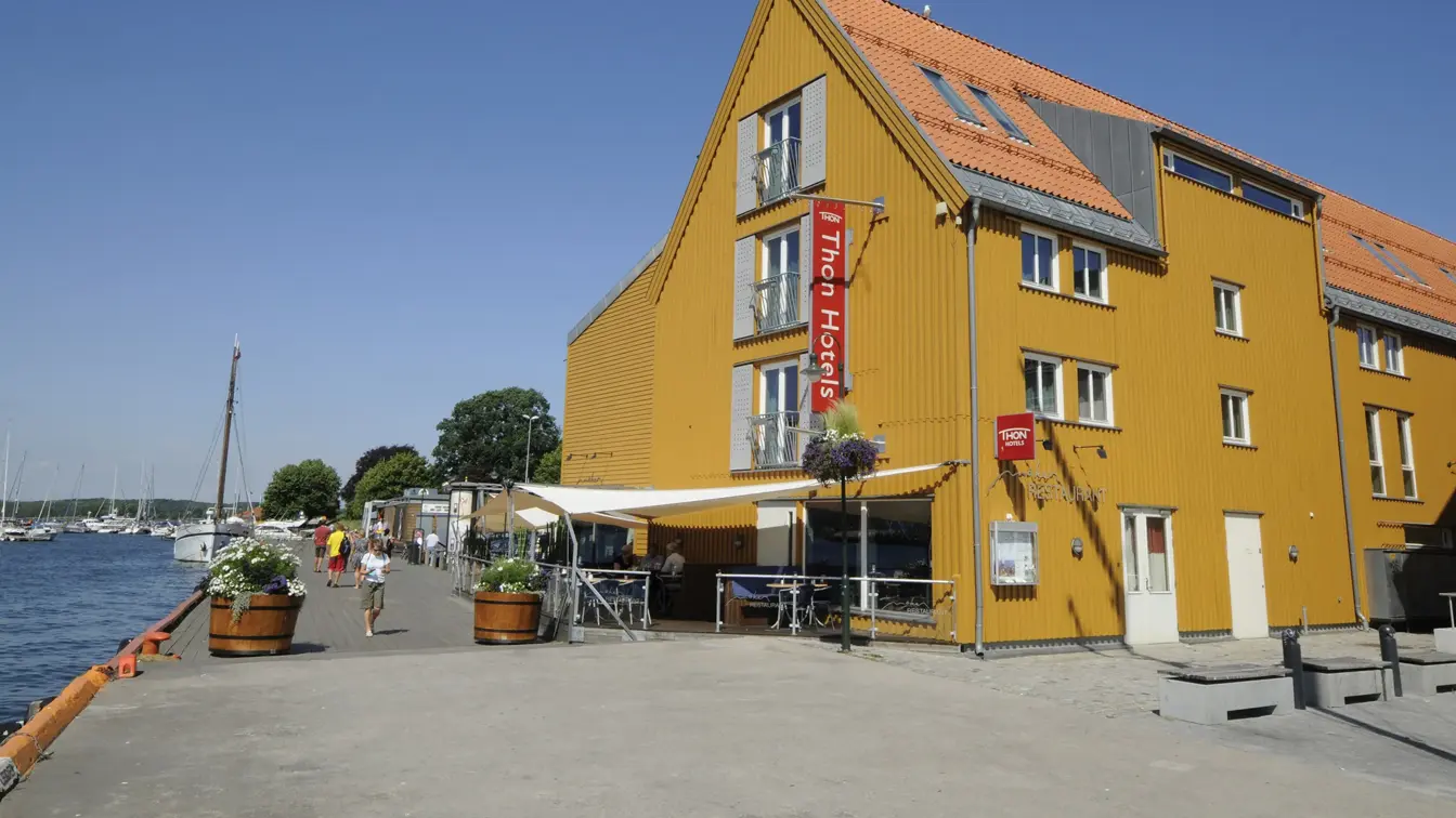 Fasaden til Thon Hotel Tønsberg Brygge med gule vegger og plassering på Brygga i Tønsberg sentrum