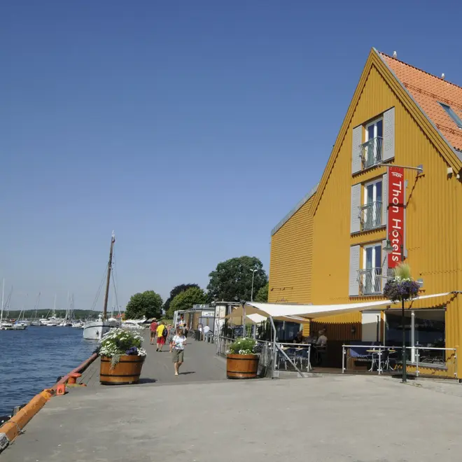 Fasaden til Thon Hotel Tønsberg Brygge med gule vegger og plassering på Brygga i Tønsberg sentrum