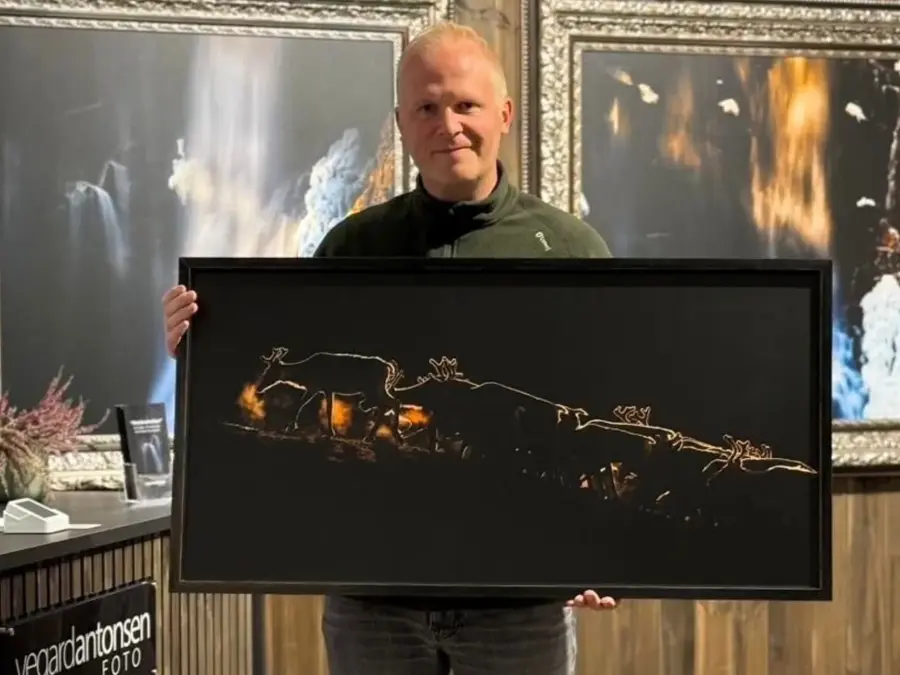 Vegard Antonsen står og poserer med et av bildene sine