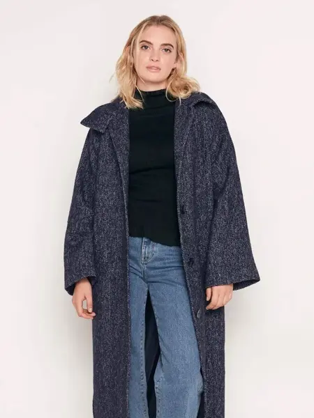 Modell som poserer i lang høstkåpe