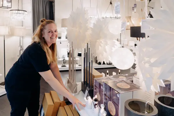 ansatt viser frem fine adventsstaker og julestjerner