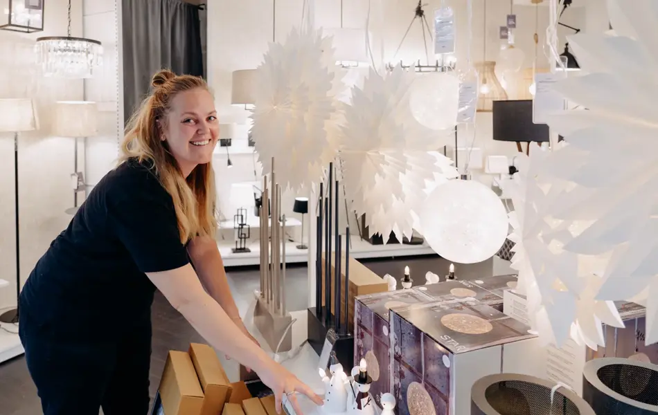 ansatt viser frem fine adventsstaker og julestjerner