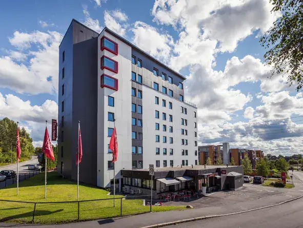 Fasaden på Thon Hotel LInne med fire Thon Hotel flagg 