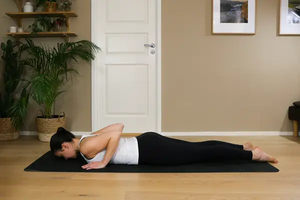 Anna viser Pilates-øvelser på treningsmatte på gulvet