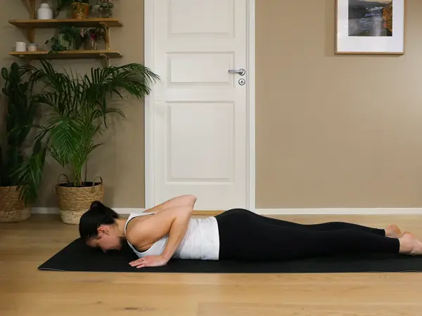Anna viser Pilates-øvelser på treningsmatte på gulvet