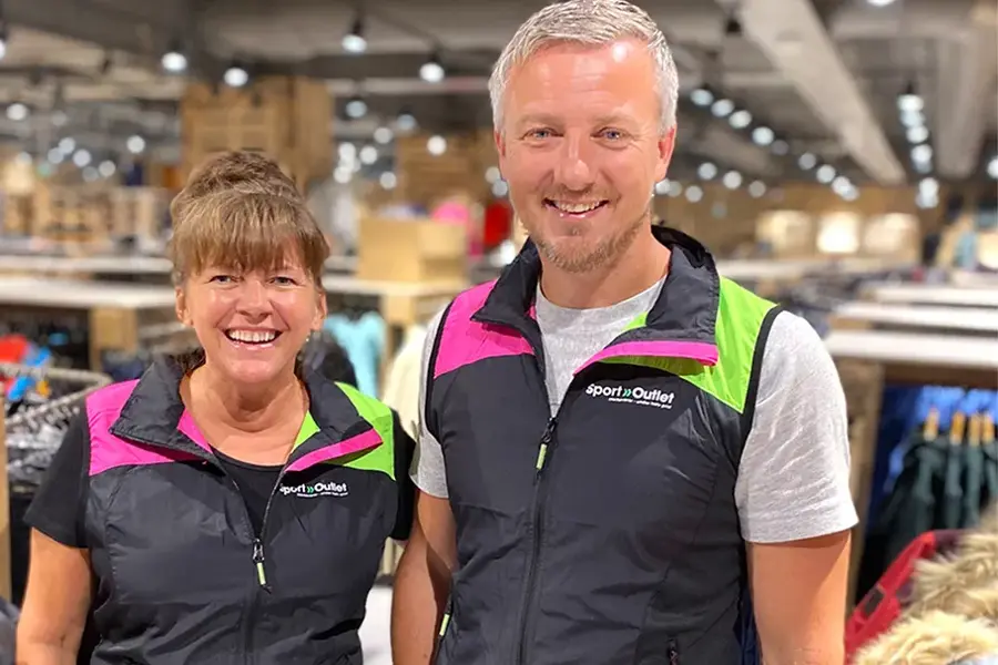 Ansatt dame og mann som smiler i butikken