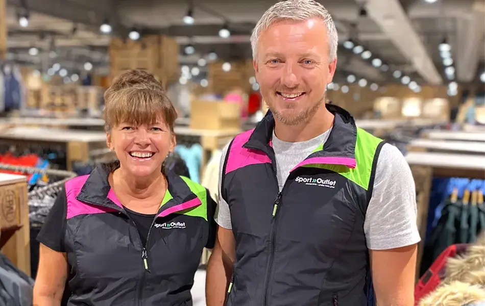 Ansatt dame og mann som smiler i butikken