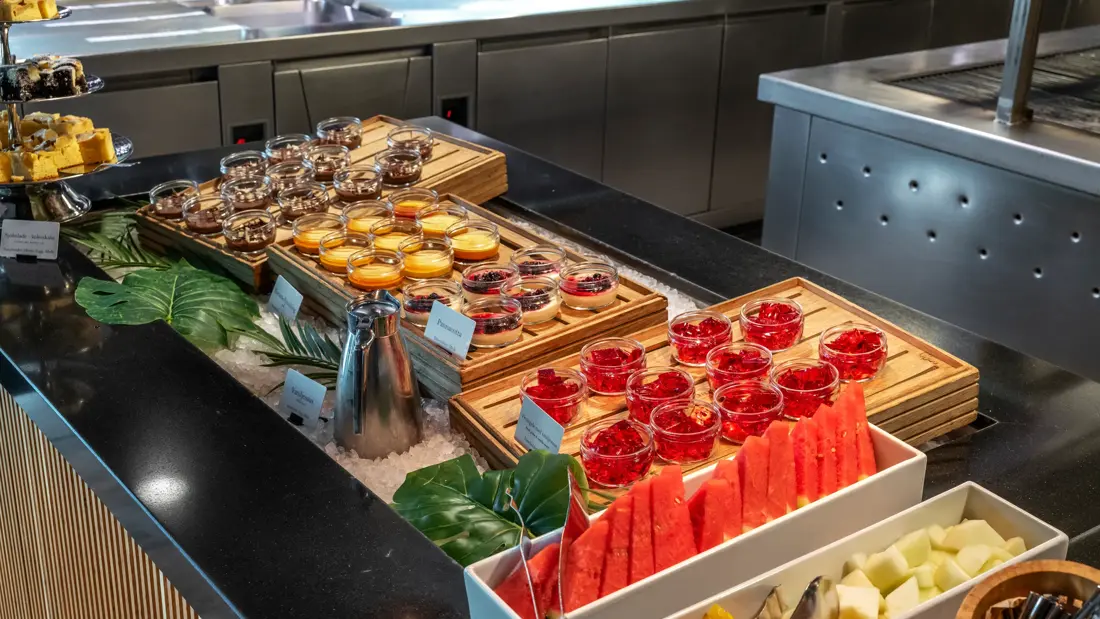 Diverse desserter og oppskåret frukt på buffet i restaurant