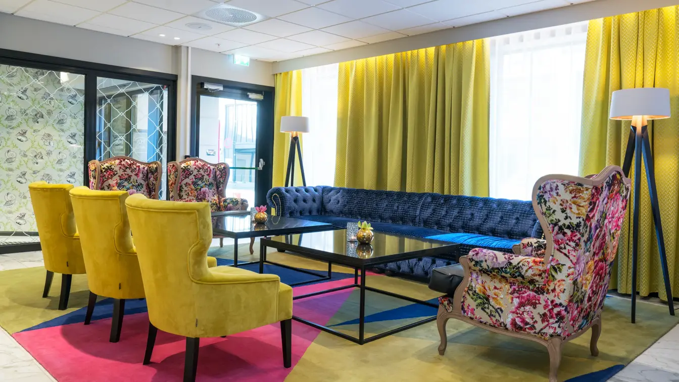 Lobby med lenestoler med fargerikt design  og sofa på Thon Hotel Arendal i Arendal sentrum