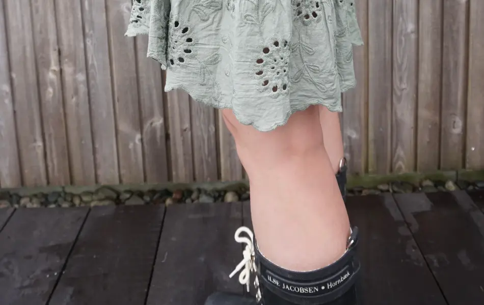 Dame i grønt skjørt og strikket genser