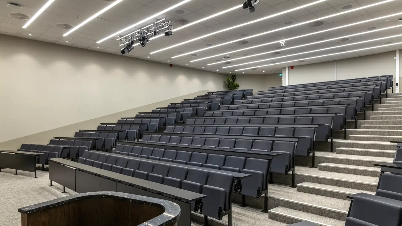 Stort auditorium sett fra scenen med talerstol.