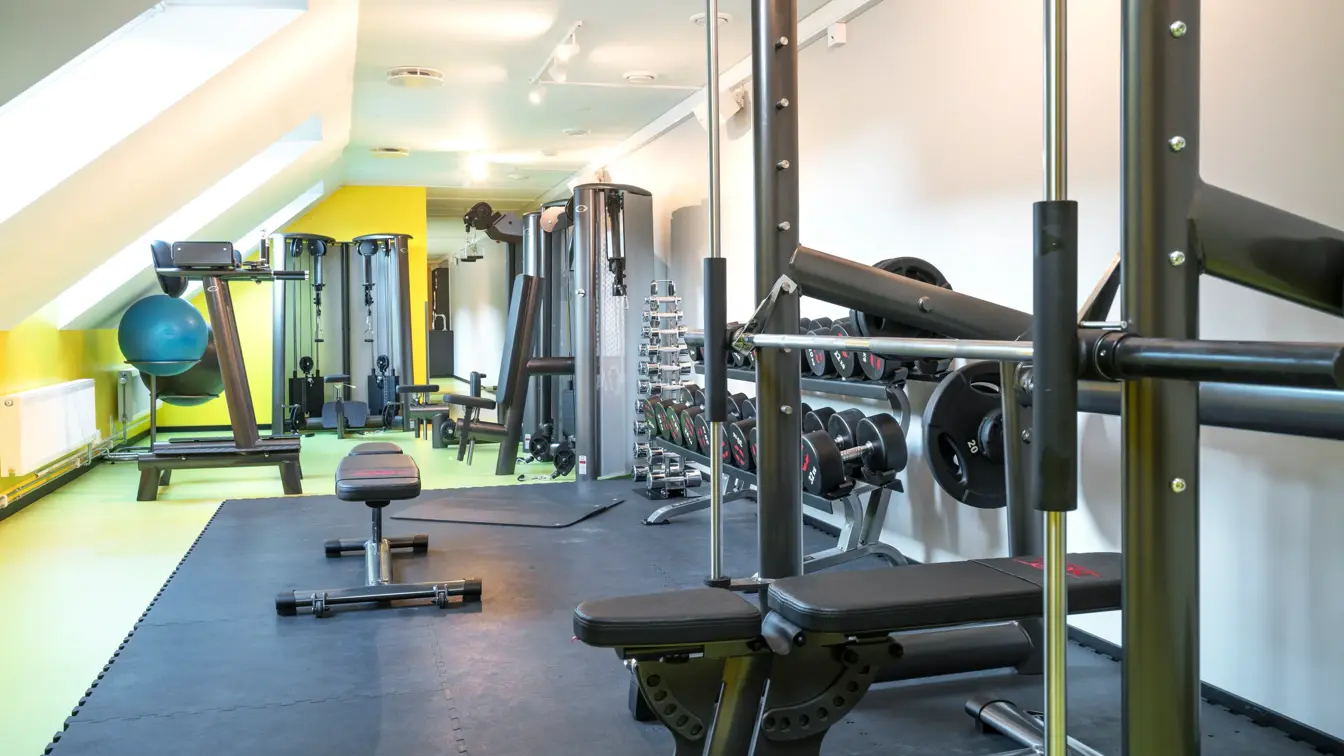 Lyse lokaler med gule gulv, treningsapparater i treningsrom på Thon Hotel Spectrum i Oslo sentrum