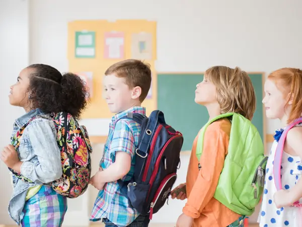 Students wearing backpacks in classroom