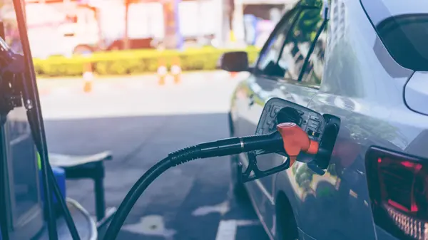 Pumping gasoline fuel in car at gas station